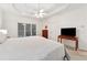 Bright bedroom featuring carpet floors, large windows, and a tray ceiling with fan at 2722 Brookhaven Ln, Buford, GA 30518