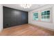 Bedroom with hardwood flooring, dark accent wall, and bright, natural lighting at 3590 Lee Se St, Smyrna, GA 30080