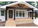 Inviting front porch with dark wood columns, exposed rafter tails, and light wood decking at 3590 Lee Se St, Smyrna, GA 30080