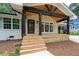 Inviting front porch with dark wood columns, exposed rafter tails, and light wood decking and stairs at 3590 Lee Se St, Smyrna, GA 30080