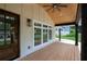 Inviting front porch with dark wood columns, exposed rafter tails, and light wood decking and fan at 3590 Lee Se St, Smyrna, GA 30080