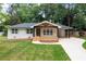 Charming single-story home boasting a spacious front yard with mature trees and a welcoming front porch at 3590 Lee Se St, Smyrna, GA 30080