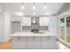 White kitchen with island, stainless steel appliances, and modern lighting at 3590 Lee Se St, Smyrna, GA 30080