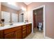 Large bathroom vanity featuring dual sinks and a doorway to a toilet room at 13042 Dartmore Ave, Alpharetta, GA 30005