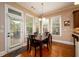 Cozy breakfast nook with natural light, wood floors, and a view of the backyard through multiple windows at 13042 Dartmore Ave, Alpharetta, GA 30005