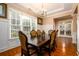 Sophisticated dining room featuring hardwood floors, a chandelier, and ample natural light from a large window at 13042 Dartmore Ave, Alpharetta, GA 30005