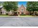 Attractive brick home with a stone-accented entrance, complemented by a well-maintained lawn and mature trees at 13042 Dartmore Ave, Alpharetta, GA 30005