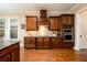 Gourmet kitchen featuring custom dark wood cabinetry, stainless steel appliances, and granite countertops at 13042 Dartmore Ave, Alpharetta, GA 30005