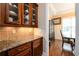 Butler's pantry with granite countertop, custom cabinets and hardwood floor between kitchen and dining room at 13042 Dartmore Ave, Alpharetta, GA 30005