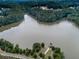 Scenic aerial view of a serene lake, surrounded by lush trees and featuring a charming lakeside gazebo at 158 South Village Ave, Holly Springs, GA 30115
