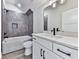 Modern bathroom with updated shower, tile, vanity, white cabinets and a large mirror creates a functional space at 158 South Village Ave, Holly Springs, GA 30115