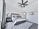 A calming bedroom features cool-toned accents, ceiling fan, and an open doorway to a bathroom at 158 South Village Ave, Holly Springs, GA 30115