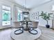 Bright dining area with modern chandelier, round table, and natural light from large window at 158 South Village Ave, Holly Springs, GA 30115