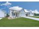 Charming home featuring a manicured lawn, inviting porch, and a two-car garage providing ample space and curb appeal at 158 South Village Ave, Holly Springs, GA 30115