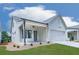 Beautiful home featuring lush green lawn, inviting porch, a two-car garage, and professional landscape for curb appeal at 158 South Village Ave, Holly Springs, GA 30115