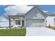 Charming home featuring a manicured lawn, inviting porch, and a two-car garage offering ample space and curb appeal at 158 South Village Ave, Holly Springs, GA 30115