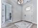 Bright foyer featuring a white front door, luxury vinyl plank flooring, and modern lighting at 158 South Village Ave, Holly Springs, GA 30115