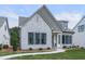 Charming single-Gathering home featuring a stone facade, manicured lawn, and black trimmed windows at 158 South Village Ave, Holly Springs, GA 30115