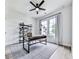 Bright home office with modern desk, open shelving, and natural light from the large window at 158 South Village Ave, Holly Springs, GA 30115