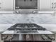 Close-up of a high-end gas cooktop in a gourmet kitchen, complemented by marble backsplash and modern design at 158 South Village Ave, Holly Springs, GA 30115