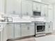 Well-equipped kitchen features modern appliances, sleek cabinetry, and ample counter space for culinary endeavors at 158 South Village Ave, Holly Springs, GA 30115