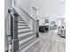 Open floorplan with staircase, luxury vinyl plank flooring, leading into the kitchen and living room at 158 South Village Ave, Holly Springs, GA 30115