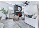 Cozy living room featuring a fireplace, ceiling fan, rug, and light-filled windows at 158 South Village Ave, Holly Springs, GA 30115