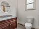 Granite vanity top in a bathroom with an oval mirror and white toilet at 187 Vanira Se Ave, Atlanta, GA 30315