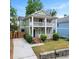 Charming two-story home with a double front porch, green siding, a driveway, and mature trees at 187 Vanira Se Ave, Atlanta, GA 30315