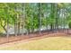 Backyard view featuring an iron fence and mature trees overlooking a tranquil lake at 3185 Casteel Ne Rd, Marietta, GA 30062