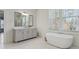 Bright bathroom featuring soaking tub, grey vanity, and marble floors at 3185 Casteel Ne Rd, Marietta, GA 30062