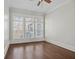 Minimalist bedroom with three large windows offering natural light and views, complemented by hardwood flooring at 3185 Casteel Ne Rd, Marietta, GA 30062