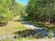 Charming dirt road through mature trees with lush greenery, creating a serene natural setting at 4146 Mcever Park Dr, Acworth, GA 30101