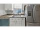 Kitchen sink next to stainless steel refrigerator with granite countertops and shaker cabinets at 713 S Fairfield Dr, Peachtree City, GA 30269