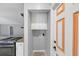 A kitchen with stainless appliances next to mudroom with orange framed door at 713 S Fairfield Dr, Peachtree City, GA 30269