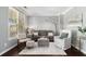Cozy living room filled with sunlight from large windows, neutral decor, and hardwood flooring at 892 Gramercy Hills Ln, Mableton, GA 30126