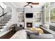 Bright living room with fireplace, custom built-ins, hardwood floors, and staircase access at 892 Gramercy Hills Ln, Mableton, GA 30126