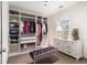 Spacious walk-in closet offering custom shelving, a bench, and natural light from a window at 892 Gramercy Hills Ln, Mableton, GA 30126