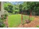 Expansive backyard featuring lush green grass, mature trees, and a sports net for recreational activities at 1160 Foster Nw Pl, Atlanta, GA 30318