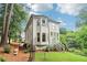 Expansive backyard with lush grass, tall trees, and a batting cage at 1160 Foster Nw Pl, Atlanta, GA 30318