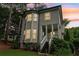 Gray two story home displaying a side porch, many windows, green bushes, and a sloping green yard at sunset at 1160 Foster Nw Pl, Atlanta, GA 30318
