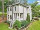 Two story home showcasing gray siding, a side porch, green bushes, and a sloping green yard at 1160 Foster Nw Pl, Atlanta, GA 30318