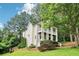 Charming two-story home with white siding, columned porches, landscaped yard, and mature trees at 1160 Foster Nw Pl, Atlanta, GA 30318