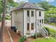 Gray two story home displaying a side porch, multiple windows, green bushes, and a sloping green yard at 1160 Foster Nw Pl, Atlanta, GA 30318