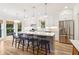 Bright kitchen with a large island, white cabinets, modern lighting, and stainless steel appliances at 1160 Foster Nw Pl, Atlanta, GA 30318