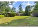 A spacious backyard with lush lawn and mature trees behind the brick home at 1594 Pine Glen Cir, Decatur, GA 30035