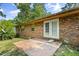 Backyard with mature trees and partial patio view of the brick home at 1594 Pine Glen Cir, Decatur, GA 30035