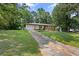 Lovely single-story home with a long driveway, well-kept lawn, and mature trees surrounding the property at 1594 Pine Glen Cir, Decatur, GA 30035