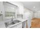 Cozy kitchen featuring white cabinets, stainless steel sink, and laminate wood flooring at 1594 Pine Glen Cir, Decatur, GA 30035