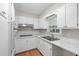 Well-lit kitchen featuring white cabinetry, stainless steel appliances, and laminate flooring at 1594 Pine Glen Cir, Decatur, GA 30035